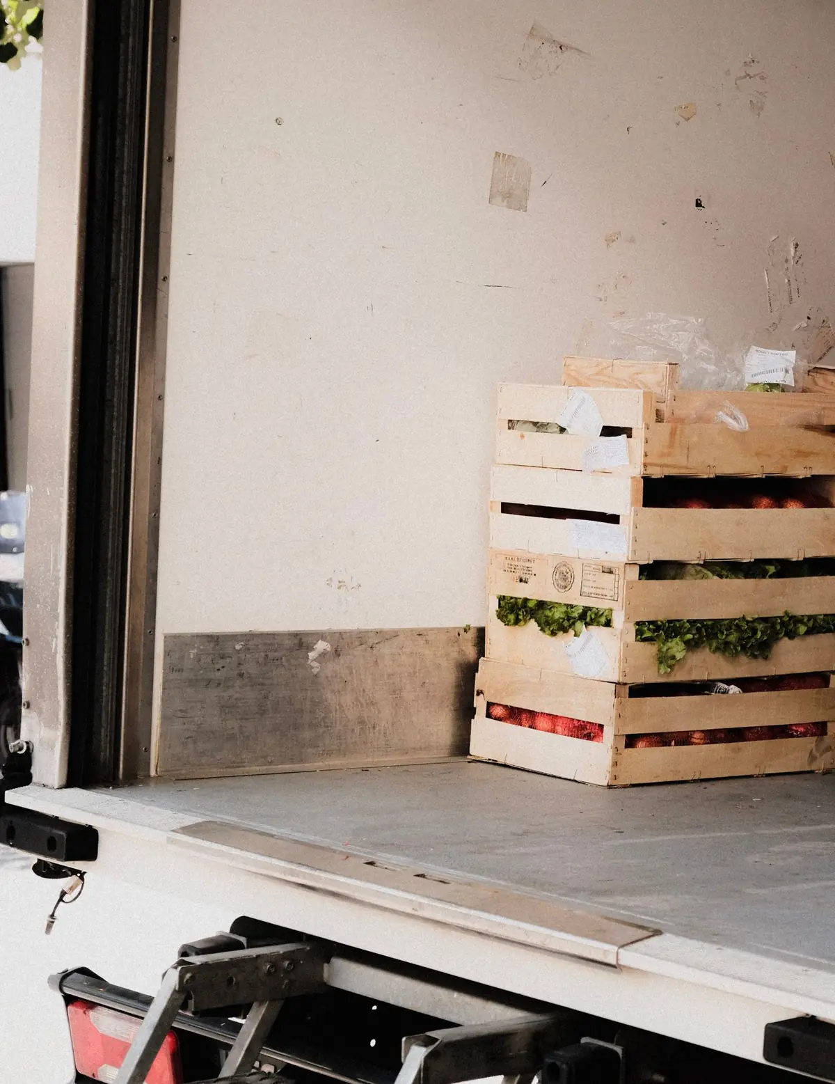 Crates of lettuce and tomatoes in the back of a delivery truck